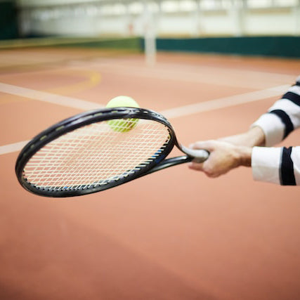 someone hitting a tennis ball with a tennis racket