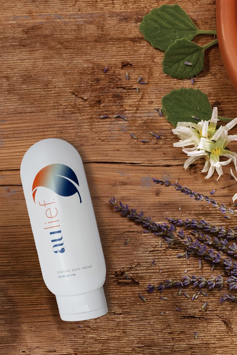 aulief 6oz tube on wooden table with lavender twigs, flowers and leaves.