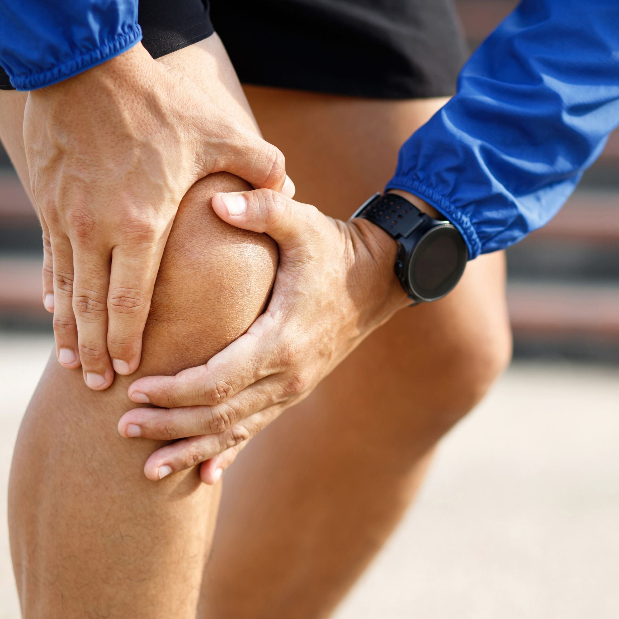 Person holding onto right knee with both hands