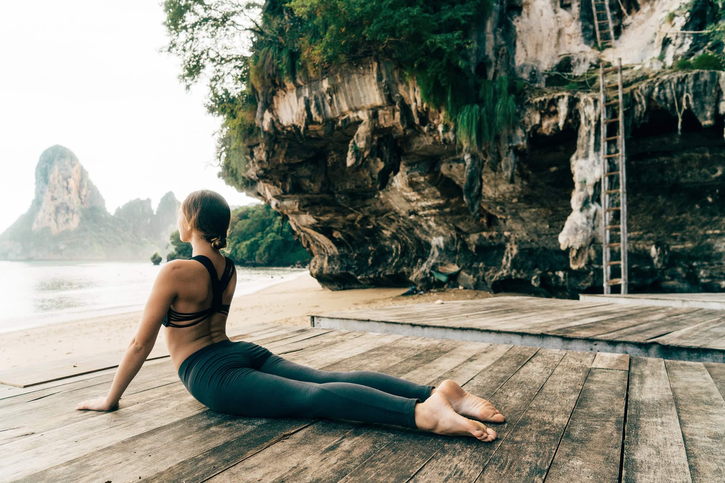 Upward facing dog pose by woman on island