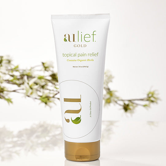 aulief gold 7oz tube with tree twig in background
