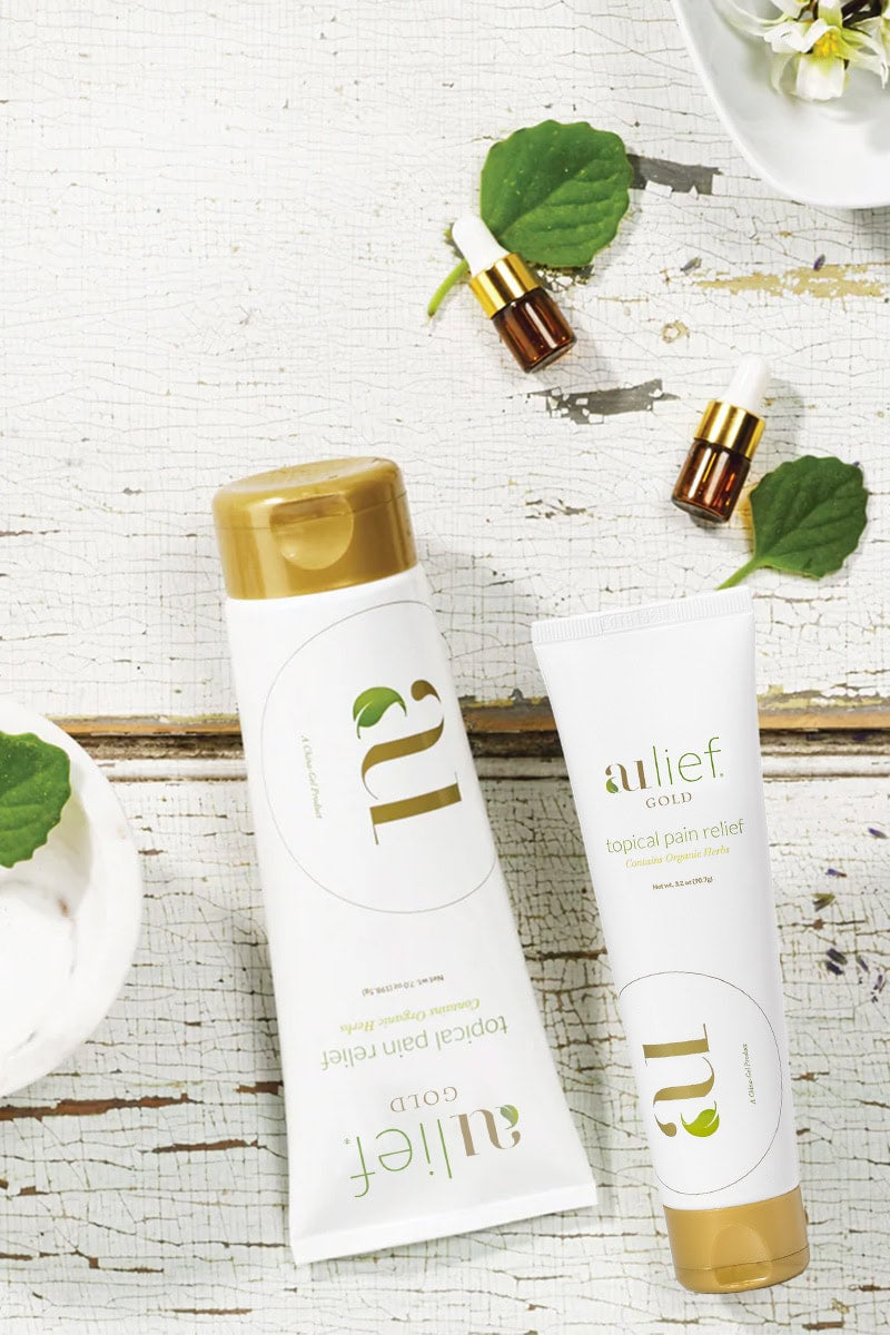 aulief Gold 7oz and 3.2 oz on wooden table with herbal oil dropper bottles