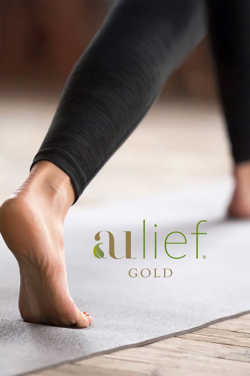 aulief Gold: pain relief as nature intended. Image showing lower legs of person doing warrior one pose on yoga mat.